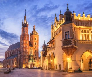 Widok na krakowski Rynek z kościołem Mariackim i Sukiennicami o zmierzchu. Open Mind Team — kościół Mariacki i Sukiennice